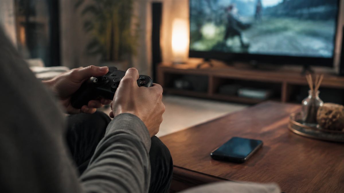 iPhone рядом с игровым контроллером в домашней комнате